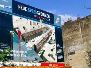 The billboard advertising the new development Neue Spreespeicher hit by color bombs showing the local resistance to the project